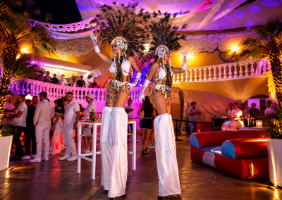 Bailarinas de zancos en fiesta neón